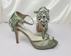 a pair of green high heeled shoes with jewel embellishments