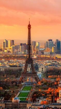 the eiffel tower in paris, france is seen at sunset with other tall buildings behind it