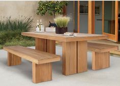 a wooden table with two benches in front of it and some bottles on the table