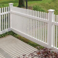 a white picket fence in front of a green lawn