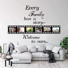 a living room with a white couch and wall decal that says, every family has a story welcome to ourss