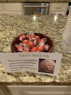 a bowl filled with chocolate covered strawberries on top of a counter next to a bottle of water