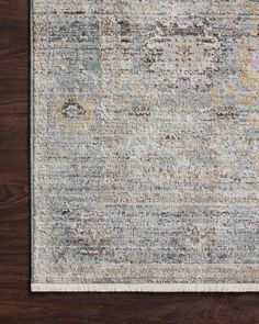 an area rug with various colors and patterns on the floor, including grays, yellows