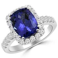 a cushion cut blue sapphire and diamond ring in 18k white gold with diamonds around the band