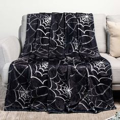 a black and white spider web blanket sitting on top of a couch