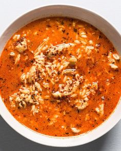 a white bowl filled with red soup on top of a table