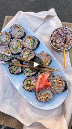 sushi is served on a plate with chopsticks