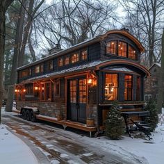 a small house is lit up in the snow