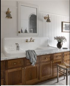 a bathroom with two sinks and wooden cabinets