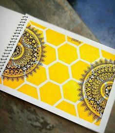 a yellow and white notebook with an intricate design on it, sitting on a table