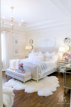 a bedroom with white fur rugs and chandelier