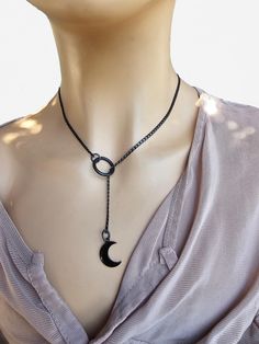 This is a bold and edgy blackened steel Gothic moon Lariat Necklace choker with a great Pagan witch aesthetic. This is a minimalistic, small curb chain with crescent moon charm.  The minimalist design gives it a trendy and stylish feel, while the black steel gives it a touch of gothic Punk edge. Please understand that this necklace is not designed for play, it is ornamental. This necklace is versatile and can be worn long or doubled up for a layered look, depending on what size you choose. Wrap it twice through the O ring to secure it in place.. PLEASE NOTE FOR RETURNS! If I accept returns on your purchase (check when ordering, some items are "no returns") your will receive a refund once I receive the item back, and your refund is MINUS  the original shipping fees, as I have already paid t Black Metal Jewelry With Moon Charm, Black Metal Moon Shaped Jewelry, Minimalist Gunmetal Jewelry For Gifts, Black Metal Moon-shaped Jewelry, Minimalist Metal Lariat Choker Necklace, Black Lariat Jewelry For Gift, Minimalist Adjustable Black Lariat Necklace, Black Metal Lariat Necklaces, Black Lariat Metal Necklace