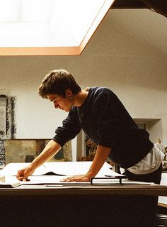 a young man laying on top of a wooden table