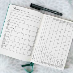 an open planner with a pen sitting on top of it