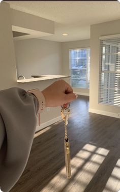 a hand holding a key in an empty room