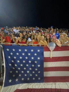 a large group of people standing next to an american flag