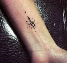 a small sun and moon tattoo on the wrist