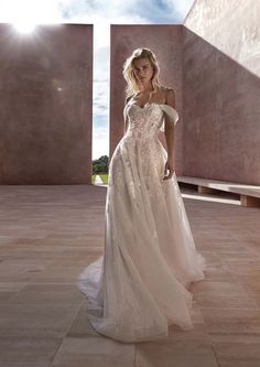 a woman in a white wedding dress standing on a tile floor with her hand on her hip