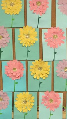 flowers made out of paper sitting on top of a blue and green background with gold accents