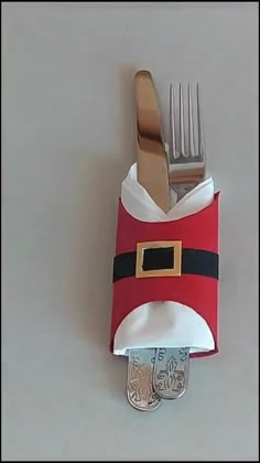 a fork and knife holder made to look like santa claus's suit on a table