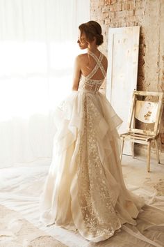 a woman in a wedding dress is standing near a mirror with the words hyper romantic gowns from recognized bridal