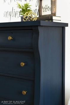 a blue dresser with a plant on top