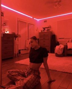 a woman sitting on the floor in a room with red light coming from her head