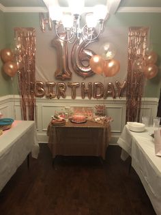 a birthday party is set up with balloons, cake and desserts on the table