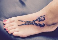 a woman's foot with a tattoo on it and a pair of scissors in the middle