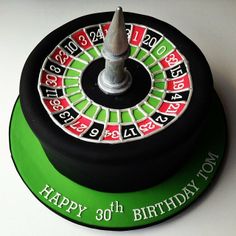 a green and black birthday cake with a rouleet on the top that says happy 30th