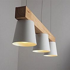 three lights hanging from a wooden beam in a room