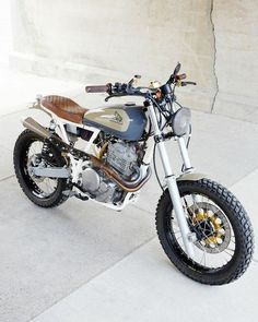 a motorcycle is parked on the sidewalk near some concrete walls and cement flooring area