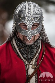 a man wearing a viking helmet and chain around his neck is looking at the camera