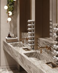 a bathroom with two sinks and several rolls of toilet paper hanging from the wall above them