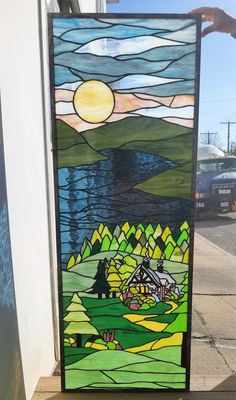 a stained glass door with a house in the background