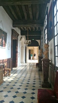 an ornate hallway with black and white checkered flooring is pictured in this image