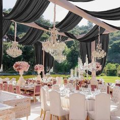 an outdoor dining area with chandeliers and tables set for formal function in the sun