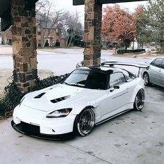 a white sports car parked in front of a gas station