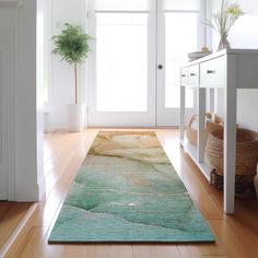 a green rug is on the floor in front of a white door and potted plant