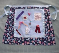 a blue and white quilted placemat with various sewing items on it's side