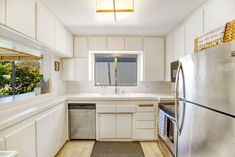 a kitchen with white cabinets and stainless steel appliances