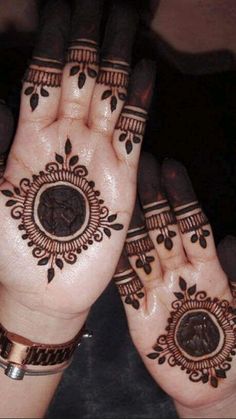 two hands with henna tattoos on them