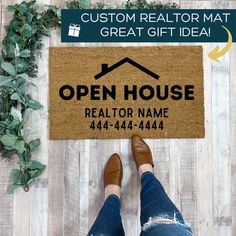 a person standing in front of a door mat with the words open house realtor name on it