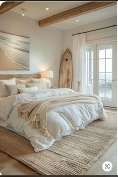 a large white bed sitting in a bedroom next to a wooden headboard and window