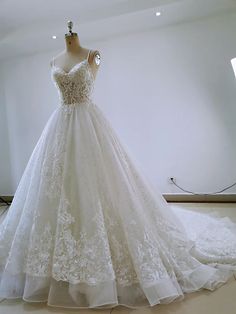 a wedding dress is displayed on a mannequin in a room with white walls