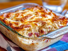 a casserole dish with meat and cheese in it sitting on a blue towel