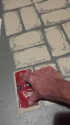 a man is painting the floor with white paint on it and he has his hand in front of him