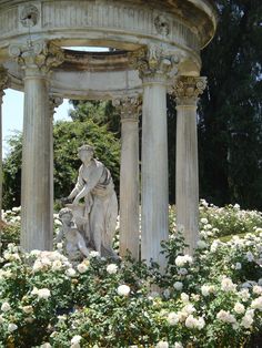 a statue is in the middle of some flowers