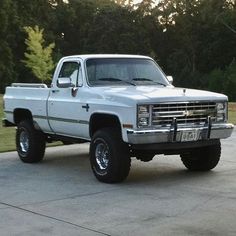 a white pickup truck parked on top of a driveway