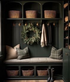 a bench with some baskets and a wreath on the wall next to it in front of a coat rack